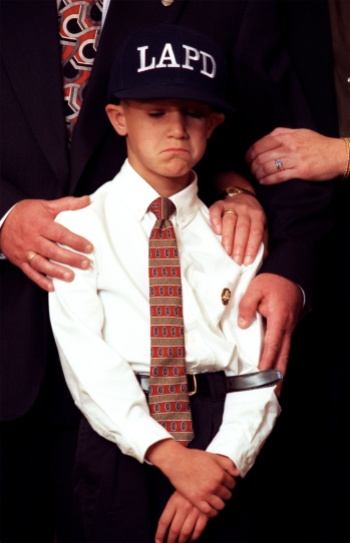 ME.Son.1.1203.RM--Dylon Brown, age 7, shows some grief at a press conference held at LAPD's Parker Certer. He is supported with the hands of his grandparents. They are Dennis and April Brown. THU folder. Photo shot in Los Angeles on 12.3.98. Rick Meyer/LAT Photo/Art by:Rick Meyer